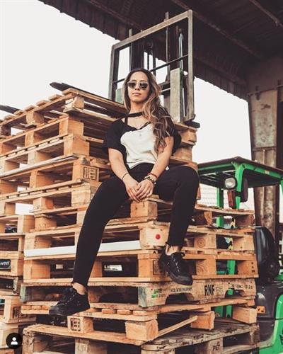 Award winning chef and social media influencer Tala Bashmi sitting on a stack of shipping pallets
