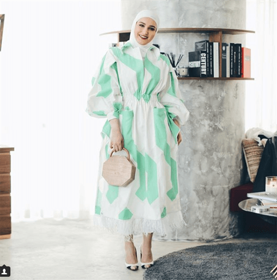 Blogger Dalal AlDoud wearing seafoam green and white dress with white hijab and octagonal purse