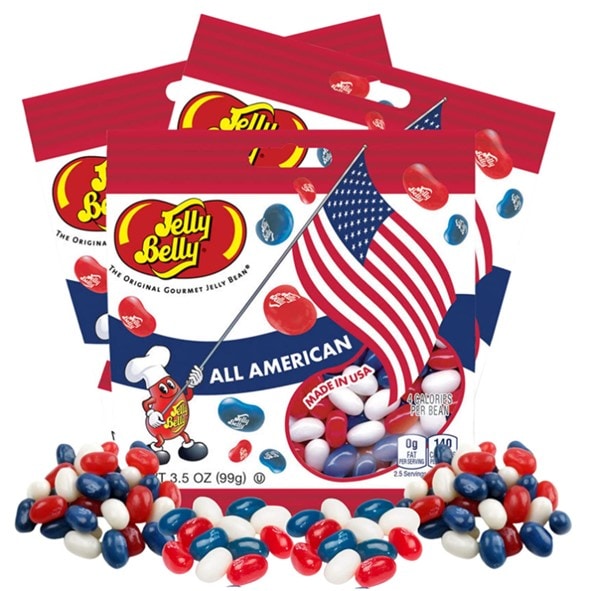 Red, white, and blue jellybeans spilled in front of three packs of Jelly Belly’s All American candy bags
