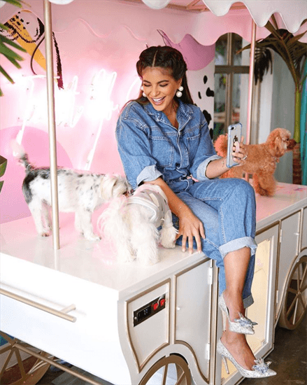 Kuwaiti influencer Bibi Alabdulmohsen sitting on a table with her dogs