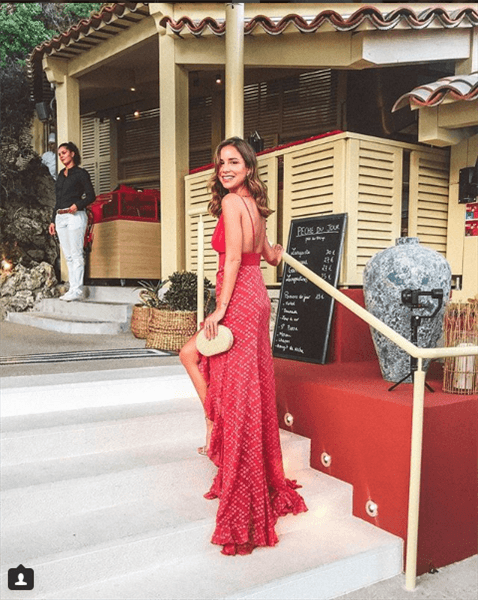 Influencer Luisa Accorsi wearing red backless dress on set of stairs