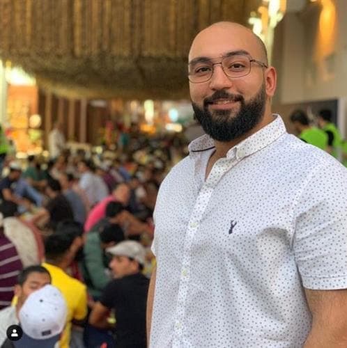 Bahraini influencer and restaurant reviewer Mohammed Wedo smiling with restaurant patrons in the background