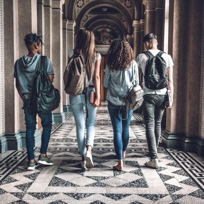 four students walking down the hall of a university