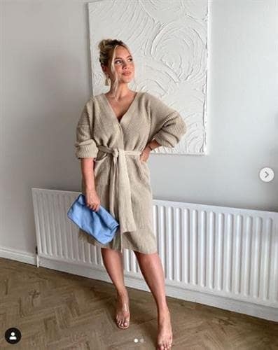 Irish influencer Elanna McGowan posing in a beige wrap dress and holding a blue bag