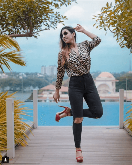 Blogger Shalini Chopra wearing cheetah print shirt and jeans with red heels