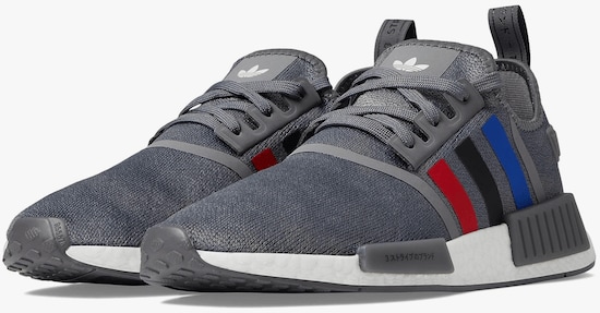 A pair of Grey Adidas Originals Nmd-R1 shoes with red, blue, and black stripes and white soles