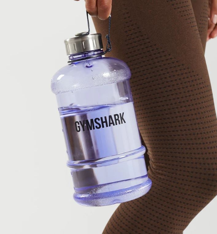 model wearing brown leggings holding a gymshark water bottle