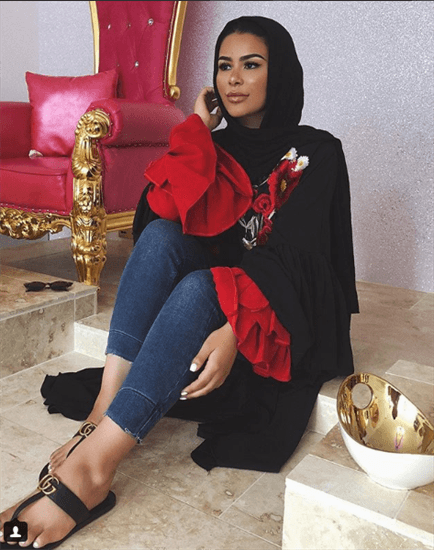 Blogger Habiba da Silva wearing black hijab and red shirt with ruffled sleeves and gucci flip flops