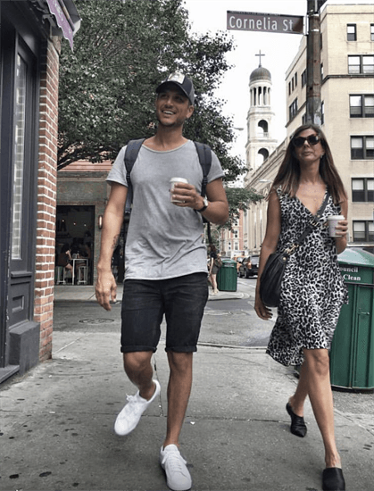 Israeli influencers Michal Ezer and Assi Ezer walking down a street drinking coffee