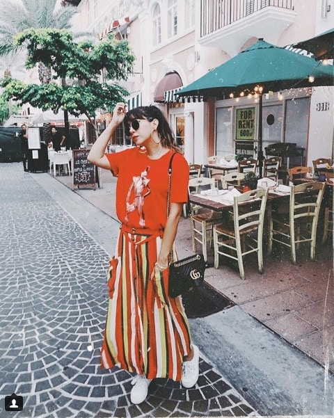 Blogger Ita Maria wearing red t-shirt with man on it and striped floor length skirt