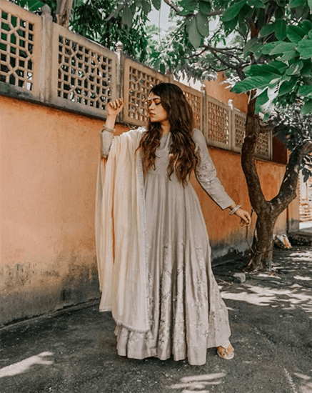 Blogger Gia Kashyap wearing beige full body gown standing next to peach wall