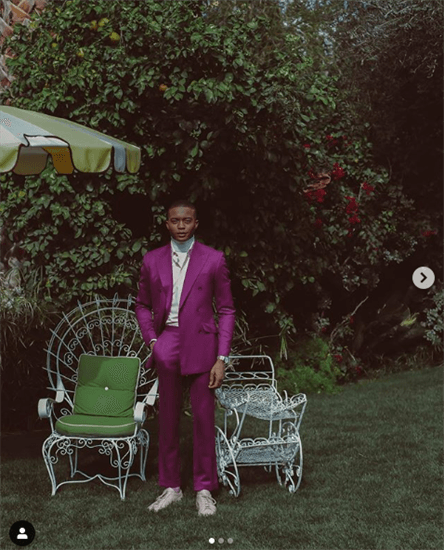 Nigerian lifestyle and menswear blogger Igee Okafor standing in a garden wearing a purple suit 