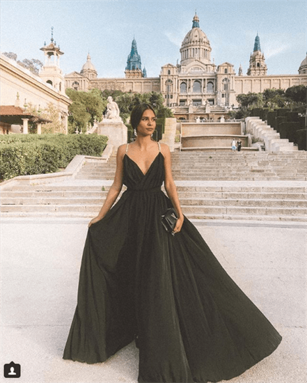 Influencer Emelie posing in black floor length gown outside a historic building in Spain