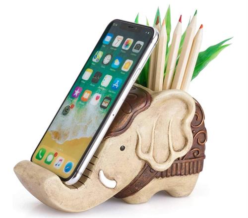 Wooden elephant phone stand and pencil holder holding a cell phone and pencils