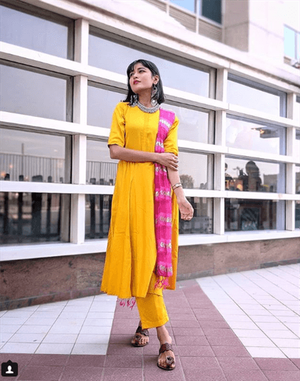 Blogger Sania Garg wearing yellow Indian garments with pink scarf across the shoulder