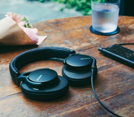 Simple black Sony headphones laid flat on a wooden table