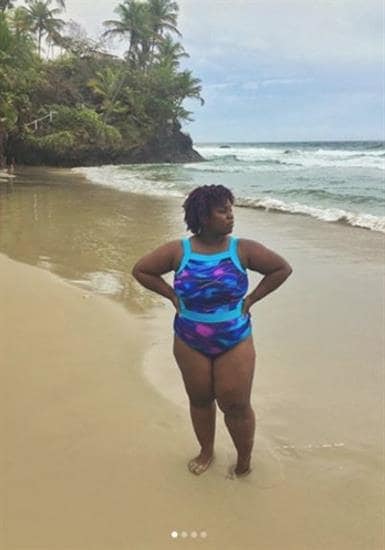 Caribbean influencer Nelly B. posing on the beach