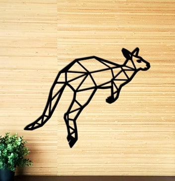 A black geometric kangaroo-shaped wall décor piece on a wooden table