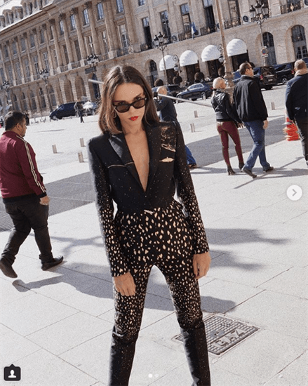 Blogger Evangelie Smyrniotaki wearing black spotted bodysuit outside building