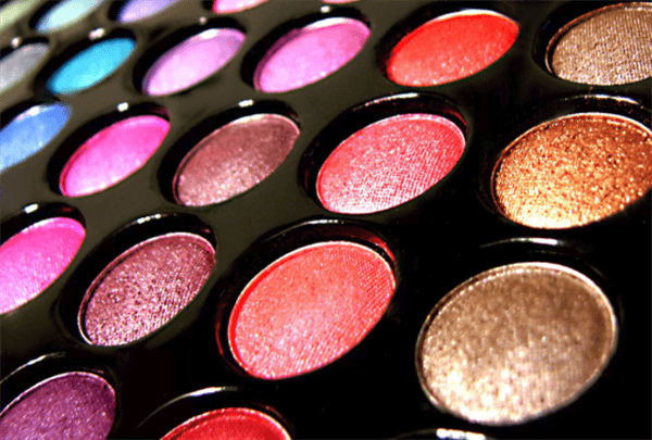 Multiple color shades of eyeshadow lined up parallel