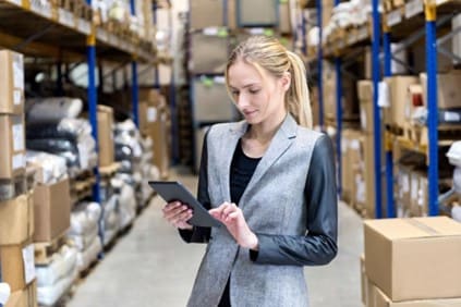 Businesswoman using a tablet in a shipping warehouse