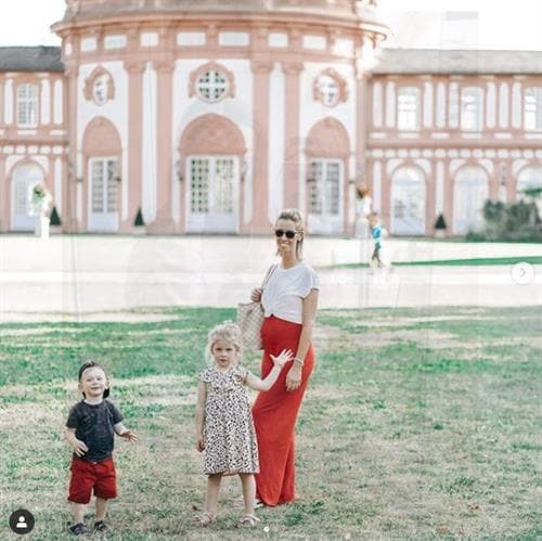 German influencer Jenny posing with children outside a large scenic building