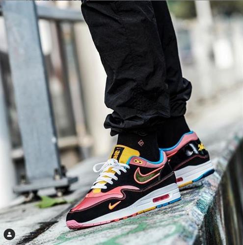 Danish influencer Jacob Kjerulff's black, pink, and yellow Nike sneakers styled with black joggers