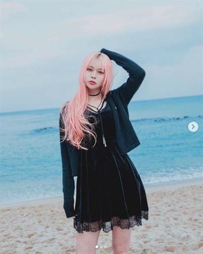 South Korean influencer EUNBI posing on the beach in a black dress and hoodie