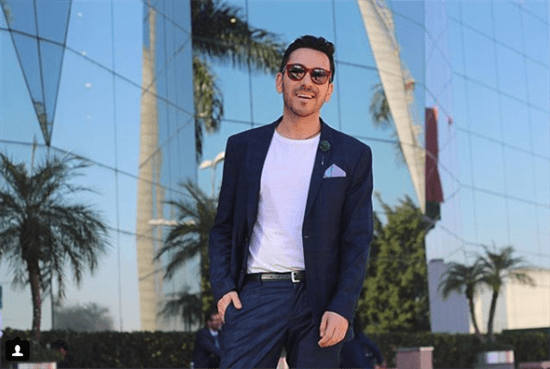 Influencer Gabriel Ibarzabal weraing navy pantsuit and light blue pocketsquare in front of mirrored building