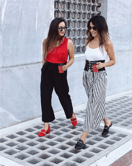 Influencers Claire & Vasia wearing tank tops and oversized pants and loafers