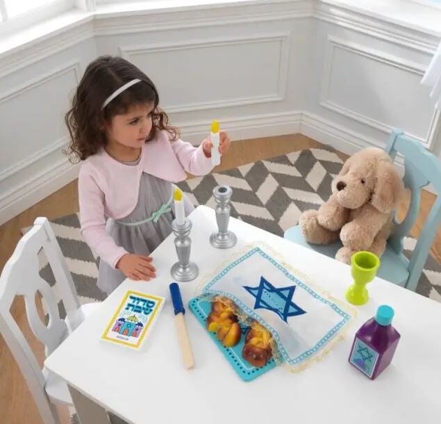 little girl playing with shabbat toys