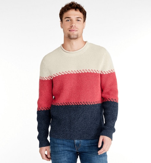 A man wearing a Mineral Red, Beige, and Navy L.L. Bean Organic Cotton Rollneck Crew Sweater with blue jeans
