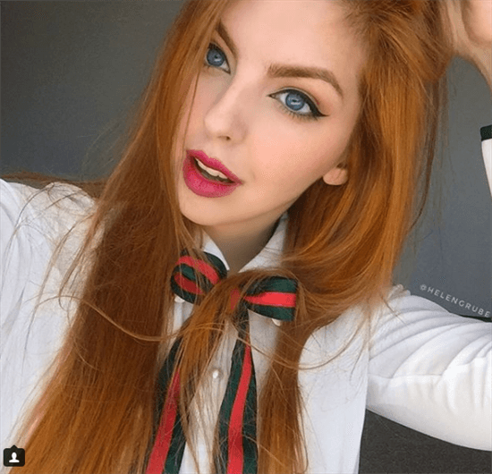 Influencer Helen Grube taking selfie wearing green and red bow around neck and red lipstick
