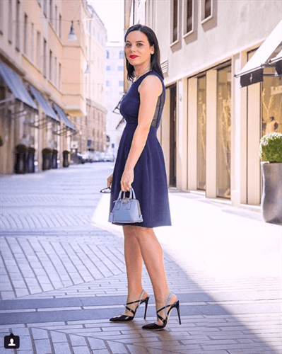 Influencer Elena Schiavon wearing a navy blue business dress with strappy heels on the street