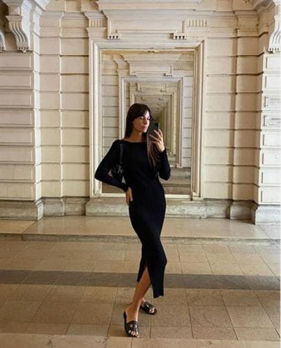 French influencer Leia Sfez taking a selfie in a long black dress 