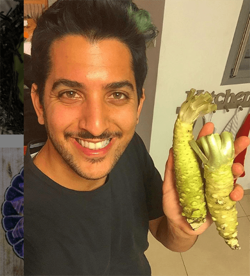 Israeli sushi chef and influencer Meidan Siboni smiling and holding up vegetables