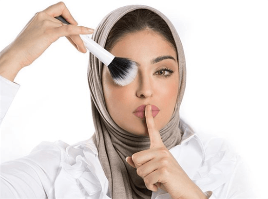 Kuwaiti beauty influencer Hanan Abdullah posing with a makeup brush