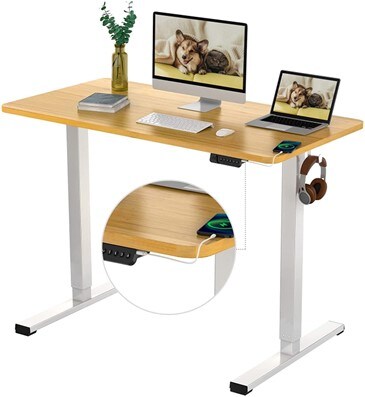 Flexispot electric standing desk with white frame and bamboo texture with laptop, desktop pc, vase, notebook, phone and hanging headphones on the side