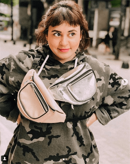 Blogger Flavia Flanders wearing camo print hoodie and two fanny packs