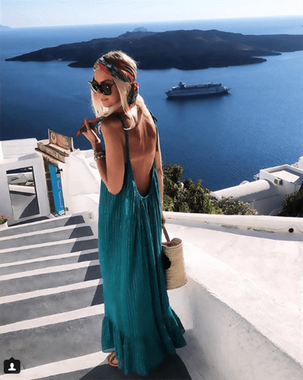 Lifestyle Blogger Anna Skoog wearing blue backless maxi dress wearing headwrap overlooking ocean