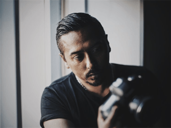 Danish photographer Bobby Anwar looking towards his camera