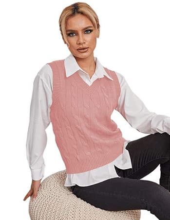 Model wearing a pink Fisoew Women's Sleeveless V-Neck Vintage Sweater over a white shirt, combined with black jeans