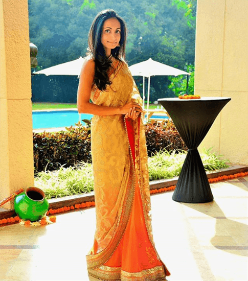 Blogger Tanya Dhar wearing gold Indian gown next to green lamp on floor