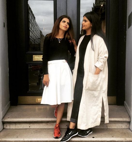 Thana & Sakhaa Abul standing on steps looking at each other