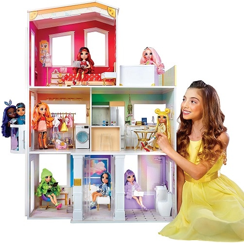 Young smiling girl playing with Rainbow High 3-story house