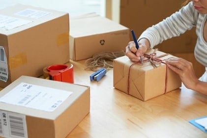 Woman preparing packages for international shipping