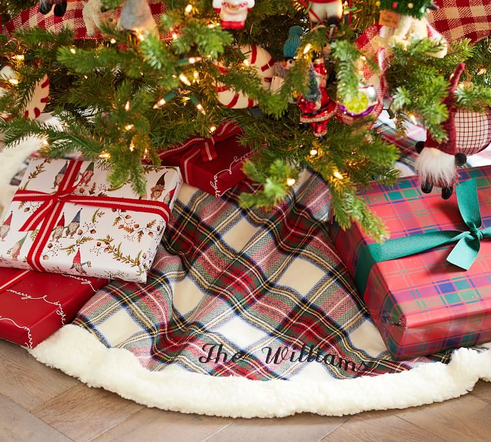 plaid pattern red, green, gold, and white christmas tree skirt with family name on the bottom