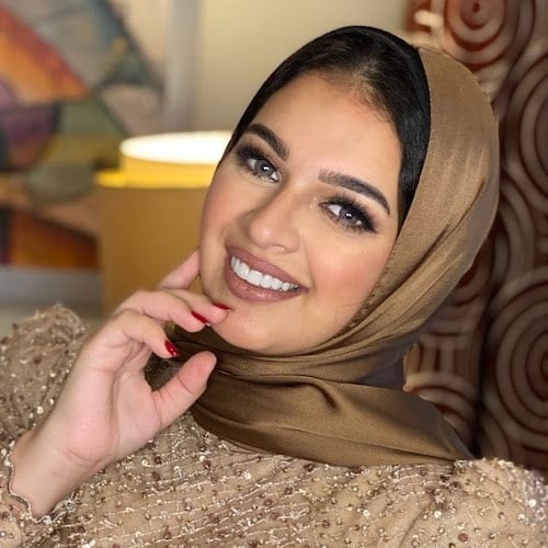 Mayada Hisham wearing a shiny solid bronze hijab and a tan dress with glittery lines and details