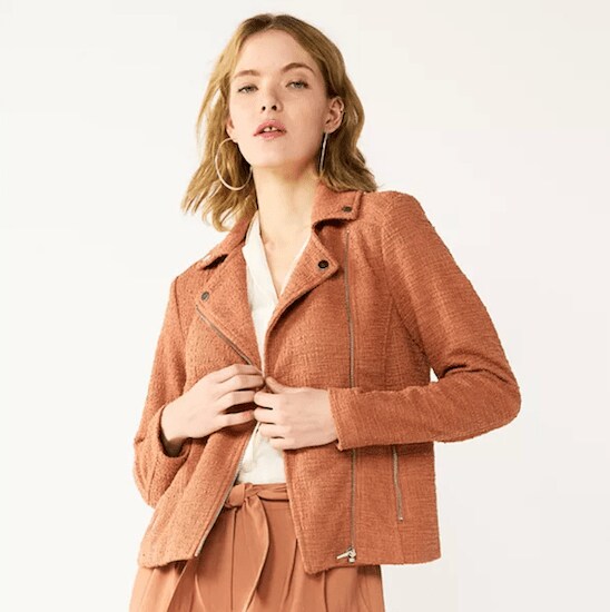 A woman wearing a Mocha Frosting Nine West Textured Knit Moto Jacket with a white button-up shirt and Mocha Frosting pants
