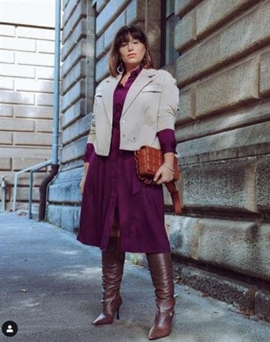 German influencer Serena in a plum dress, cream blazer, and brown knee high boots